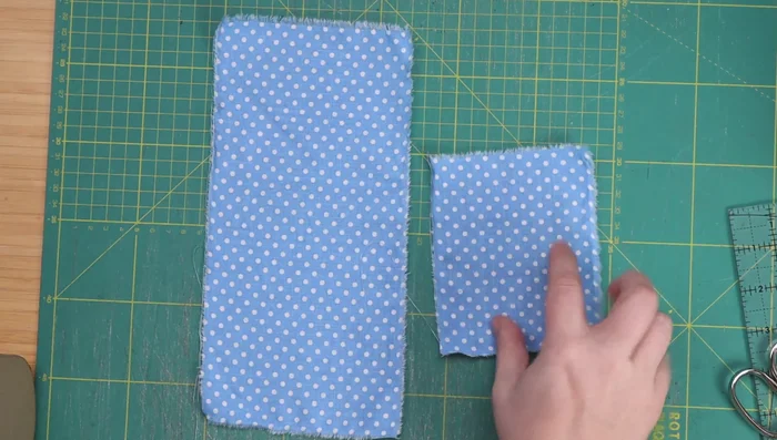 Cut fabric pieces for Cat Quilt Block 1: One 5x10 inch patterned rectangle, one 3x5 inch patterned rectangle, two 2.25x2.25 inch patterned squares, two 2.5x2.5 inch patterned squares, one 5x5 inch white square, one 5x2 inch white rectangle, and one 2.5x2.5 inch white square.