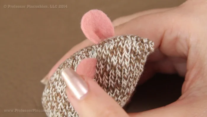 Pin the ears onto the mouse body (about 1.25 inches from the nose). Sew the ears using a whip stitch, securing them to both the ear and the sock material.