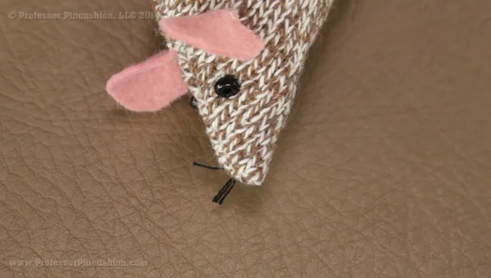 Add whiskers using embroidery floss. Tie a knot at the base of the whiskers, trim to desired length.