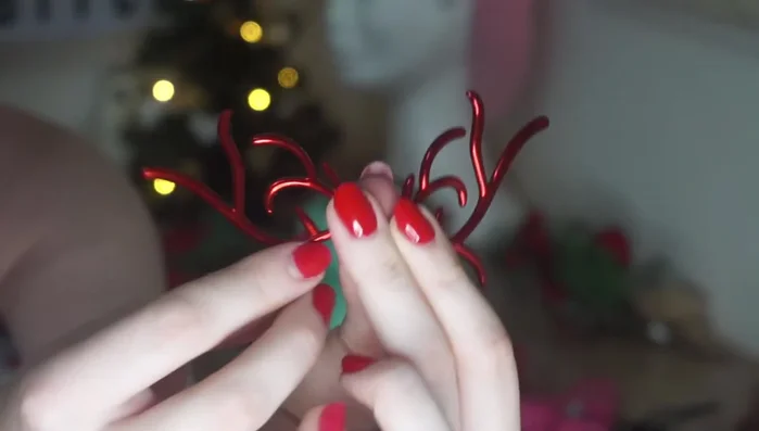 Attach deer antlers from a headband to the crown using hot glue.