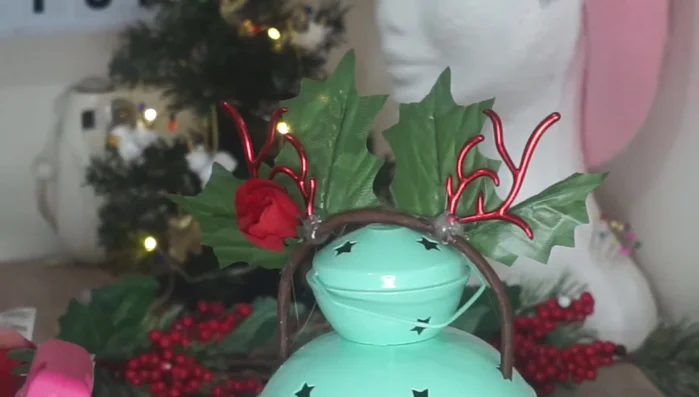 Glue small red roses along the base, in front of the leaves.