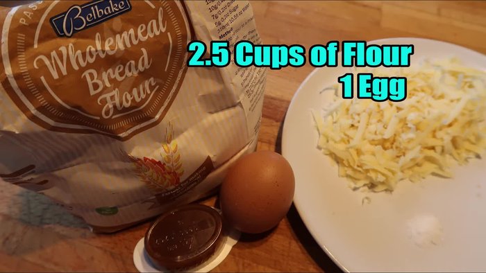 Combine 2 1/2 cups of wholemeal flour, 1 egg, 40 grams of cheese, 1 chicken stock cube (dissolved in 1/2 cup of hot water) in a bowl.