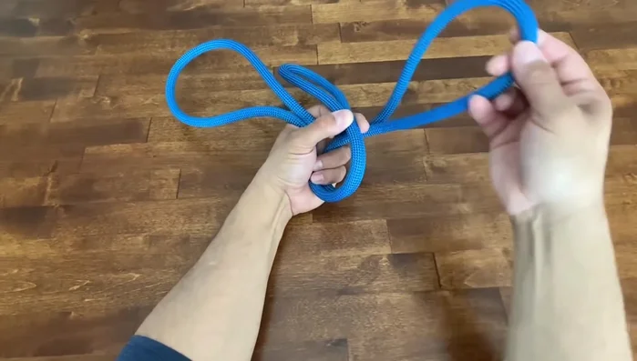 Adjust the knot and pull it tight. Ensure the seam is on the inside.