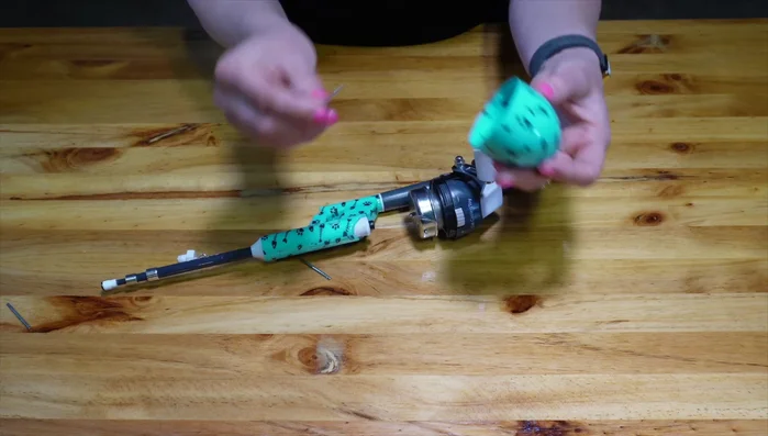 Put the weight through the top of the reel and fasten it back on.