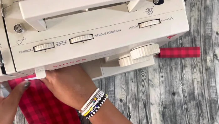 Sew and secure the bow: Sew the folded bow together, cut excess fabric, and secure the small bow piece around the center.