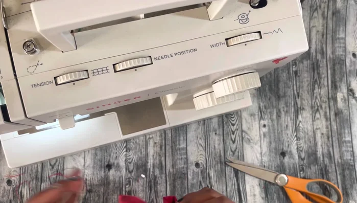 Sew and secure the bow: Sew the folded bow together, cut excess fabric, and secure the small bow piece around the center.