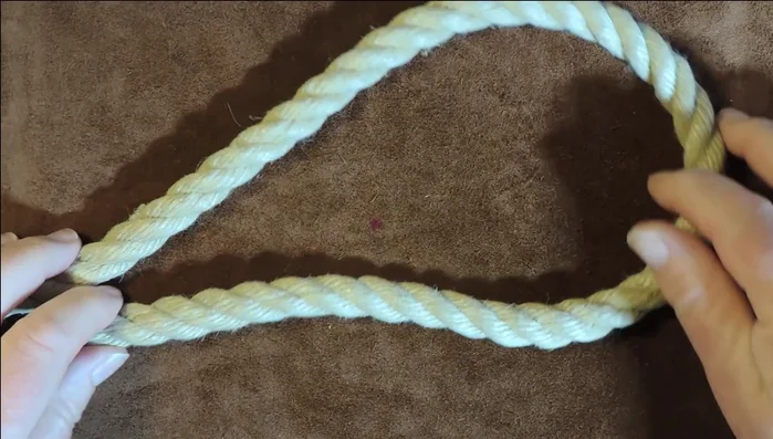 Attach the clip to one end of the rope and feed the rope through the three loops, creating a Cat's Paw eye splice. Tighten securely.