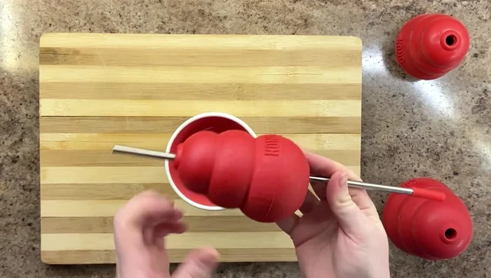 Kibble Stew: Insert a straw through the Kong to prevent an air seal. Fill with kibble and add beef broth before freezing.