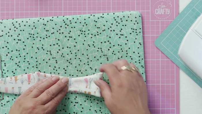 Create the center of the bow by bringing one-third of the fabric up and tacking it in place. Repeat on the other side.