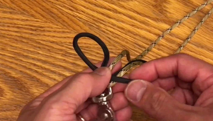 Create a tight knot using the alternating paracord strands, tucking each strand under and into the loop.