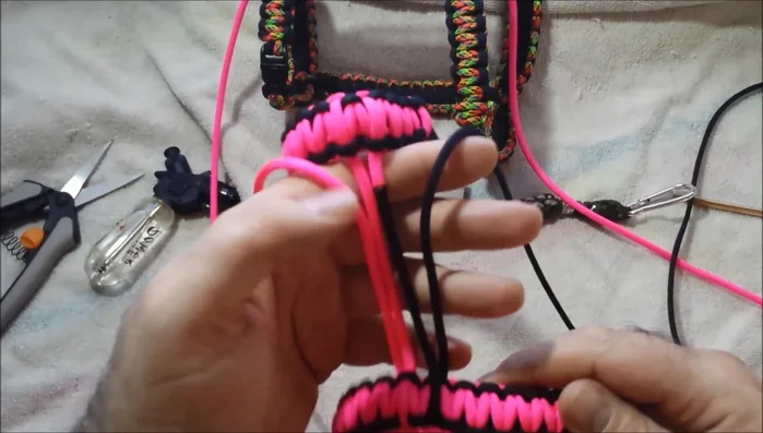 Continue the 4-strand cobra weave. Starting from where the neck and body pieces are joined, weave the paracord to complete the harness. This section creates the 'chest strap' of the harness.