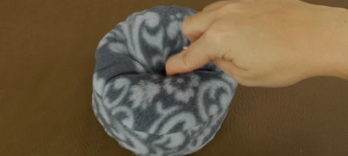 Optional: Create a dimple in the bed using embroidery floss. Insert the needle from the bottom, pushing through to the center top. Repeat on the opposite side. Tie knots on the bottom to secure.