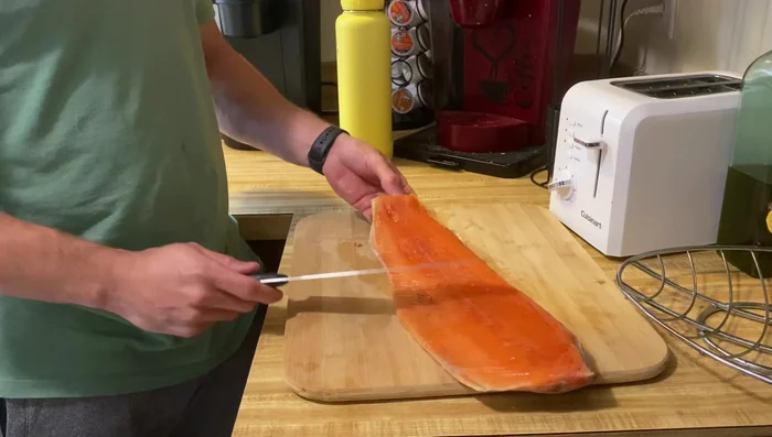 Remove the salmon skin. Use a technique of slicing into the skin, then turning the knife and peeling it off.