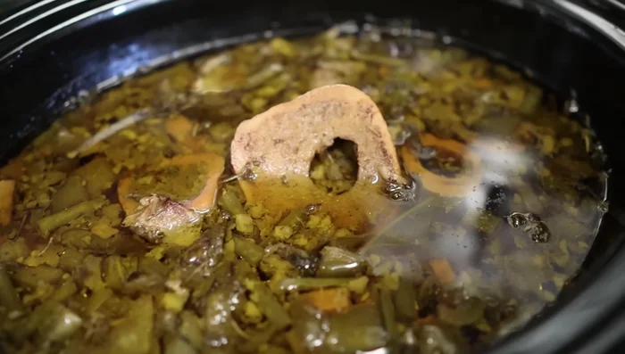 Let the broth cool slightly before straining through a colander and then a fine-mesh strainer to remove bones and solids.