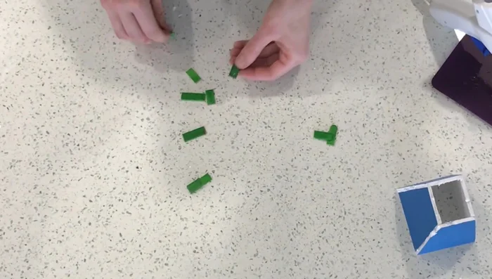 Cut popsicle sticks into 1-inch and 1/2-inch pieces. Make four double-layered pieces for the elastic to attach to.