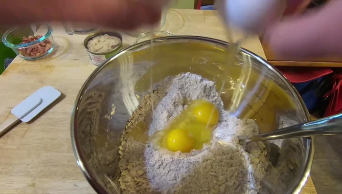 Mix all ingredients together: 4 cups whole wheat flour, 1/2 cup oats, 2 eggs, 1 can salmon, 1/2 cup peanut butter, 2 tablespoons bacon pieces, and a little water at a time (until dough isn't too sticky).