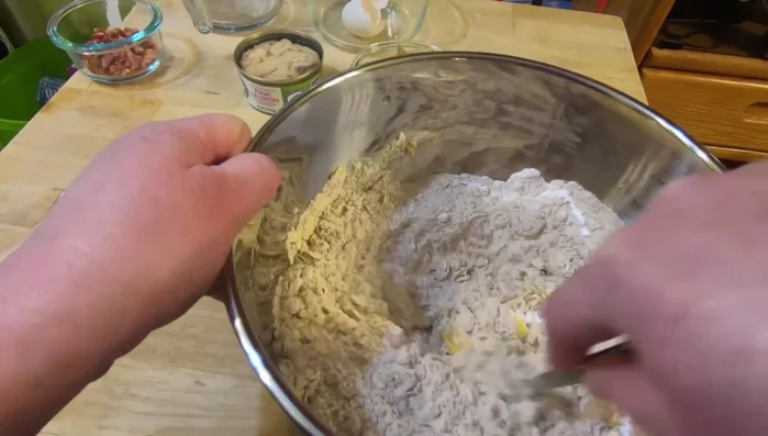 Mix all ingredients together: 4 cups whole wheat flour, 1/2 cup oats, 2 eggs, 1 can salmon, 1/2 cup peanut butter, 2 tablespoons bacon pieces, and a little water at a time (until dough isn't too sticky).