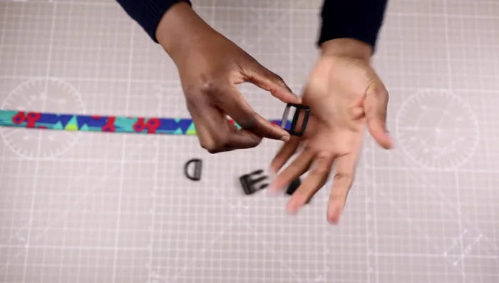 Attach the triglide: Place the triglide (curved side down) and insert the collar from the top into the first opening, then pull it out through the other opening. The length of the flap should be between 1.5 to 2 inches.