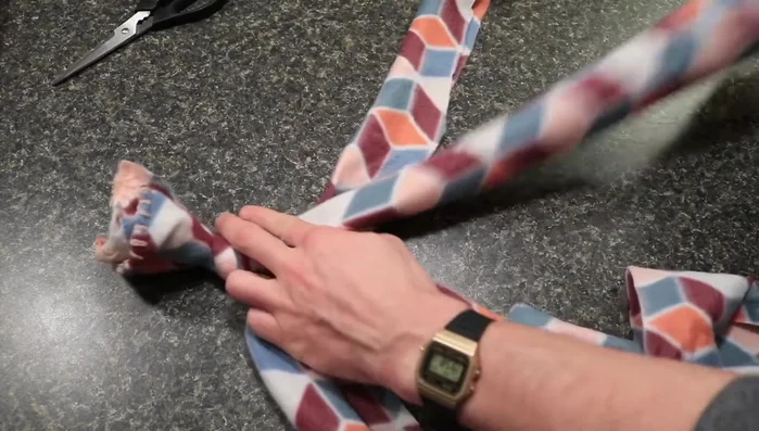 Begin braiding: Braid the four strips tightly. The first few braids might be tricky, but keep the braid tight to prevent loosening during play. A technique is described in detail around 505.36 seconds.