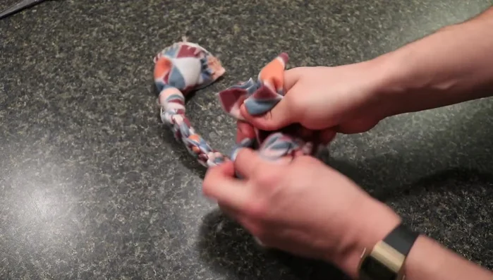 Finish braiding: When you reach the end, loop the remaining fabric and tie another knot, securing all ends. Pull the knots tight to create a durable toy.