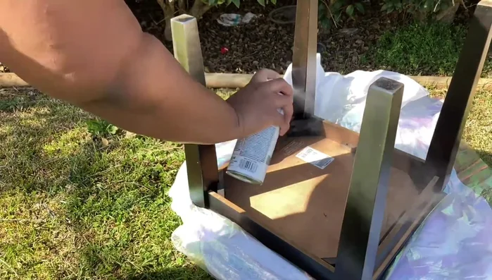 Spray paint the entire end table with metallic spray paint, followed by glitter glass spray paint, glitter protection, and a high gloss protection.