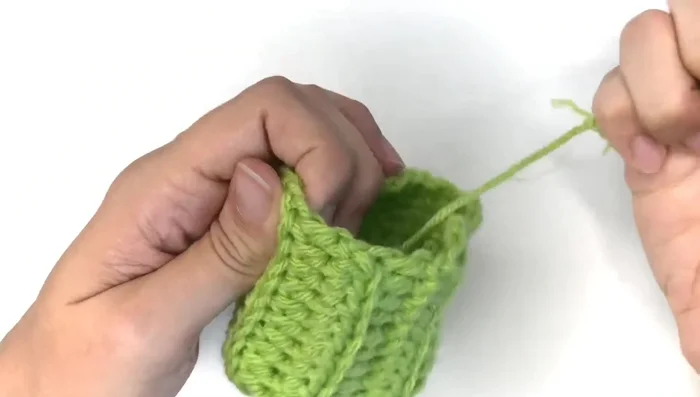 Turn the piece inside out. Use the tail to close the opening by sewing through both layers of fabric.