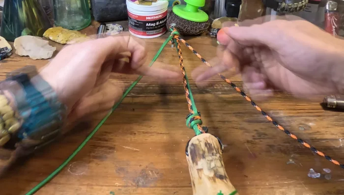 Begin the Cobra Weave: Start a standard cobra weave with the long paracord strands, going down and back up the stick.