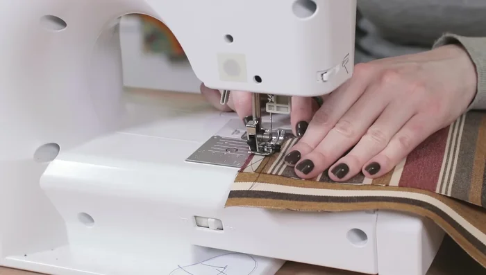 Sew along the edges of the velcro on the bottom piece. Fold the end in half an inch and sew on the velcro.