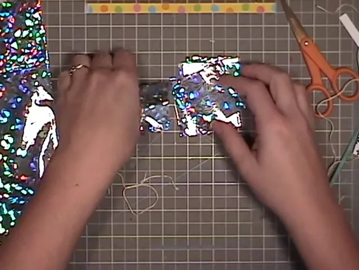 Prepare a length of string and tie a knot around the bunched squares.