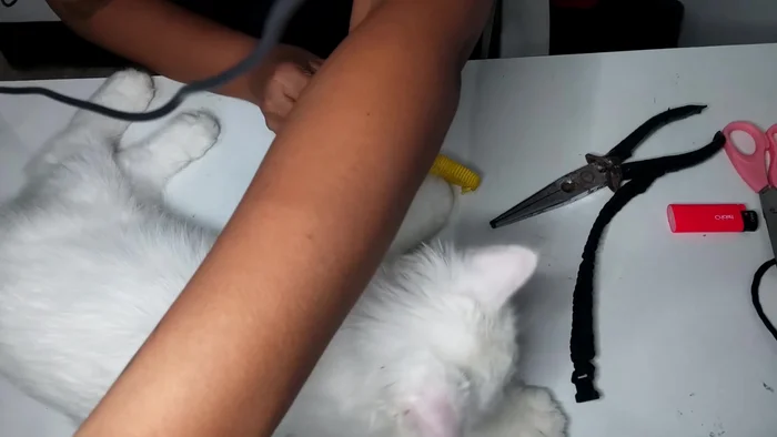 Create a small slit in the center of the unbraided portion of the string.