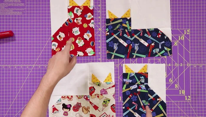 Assemble the quilt blocks: Arrange four cats (two laying down, two standing, facing each other) and sew 2.5 inch sashing strips between them.